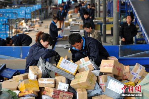 资料图：快递人员正在分拣大量包裹。 <a target='_blank' href='http://www.chinanews.com/'>中新社</a>记者 韦亮 摄