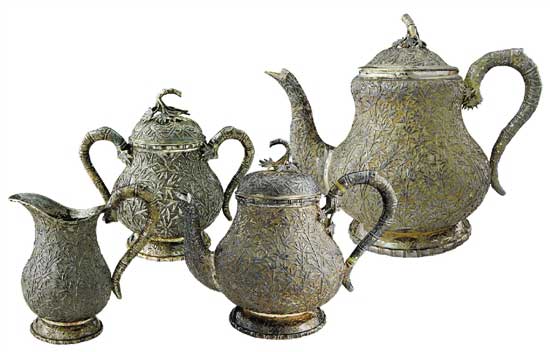 竹林摇曳茶具   Tea Set with Bamboo Forest Pattern　　咖啡壶 通高：18cm；腹径：13.5cm；重：727g   茶壶 通高：15.5cm；腹径：10.5cm；重：421g　　糖缸 通高：10.5cm；腹径：7.5cm；重：186g    奶缸 通高：9.5cm；腹径：6cm；重：131g　　款识：仪昌，伦巴 H    这套茶具使用了锤碟工艺，壶身通体附有竹枝竹叶，紧密相间，具有微风摇曳之动感，壶把手和流均为竹节附竹叶型。在茶具的细节之处体现了匠人的精心设计，银制茶具导热性极强，为防止茶壶把手过烫，凡是装热饮的茶壶、咖啡壶把手处都装有一白色象牙制圆环，俗称“象牙隔热”，用以阻断把手部分的热传导，做到美观大方与实用功能同时具备。壶体留有光面盾牌用以刻族徽，壶底外圈錾刻竹叶纹，有中国梅兰竹菊的款式风格在里面。该套茶具未经任何处理进行展示，表面留有一层氧化层，专业术语称之为“包浆”，以为对比之用。晚清外销银器盛极一时，但缺乏国内市场导致其很快衰落，至民国中后期逐渐销声匿迹，一方面是由于银器造价昂贵且国人没有使用银制器物的习惯，而另一方面则是银器需要大量的时间与精力进行维护，如若不经常擦拭，很容易表面氧化而失去光泽，这也使得银器的使用成本进一步提高，这正是银器逐渐没落的原因。可惜的是，中国传统手工业的传承大都是师徒制，而缺乏了市场需求的银器匠人招不到学徒，精湛的工艺面临着失传的窘境。