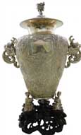 人物故事龙耳瓶   Dragon-shape-handled Vase with Figures and Story Scene Pattern   晚清 带座通高：57cm；不带座通高：49cm；腹径：27cm；不带座重：3276g 款识：德昌，HUNGCHONG&CO   银器实用性、观赏性兼具，一直深受西方人的喜爱，很多时候都作为礼物和奖品的不二选择。这件人物故事龙耳瓶，瓶钮及两侧的双耳皆以龙首为造型设计，加之器型高大，整体极具气势。两侧双耳是以龙首口中吐出的流水形成下沿，通身布纹为底，通过锤揲工艺创作出刀马人物故事图，底座被设计成三名孩童双手捧持瓶底，下方配一紫檀底座，极具艺术感。

　　除开整体造型及瓶身上繁复的纹饰外，最引人著目的当属瓶身中部的方形铭牌，在中日甲午战争中，数位德、英官兵曾在北洋舰队上协助作战，而在铭牌上的德语铭文，正是向这批德、英军士们致以最崇高的敬意，也使得这件器物成为了中日甲午战争的历史见证之一，更显珍贵。