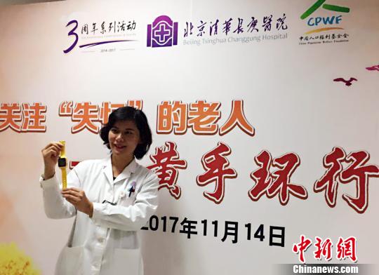 北京清华长庚医院首批29位患阿尔茨海默病的患者发放免费“黄手环”。图为北京清华长庚医院神经内科副主任医师张菁介绍“黄手环”用法。　杜燕 摄