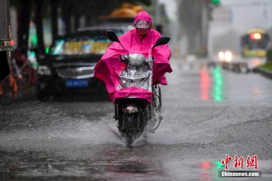 资料图：10月15日，海口民众雨中涉水骑行。<a target='_blank' href='http://www.chinanews.com/'>中新社</a>记者 骆云飞 摄