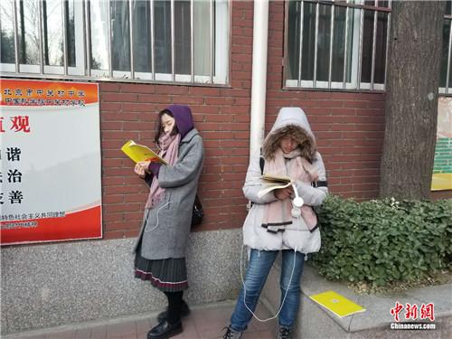 12月10日早7时30分许，北京市中关村中学(双榆树校区)，两名考生在室外进行考前复习。冷昊阳摄