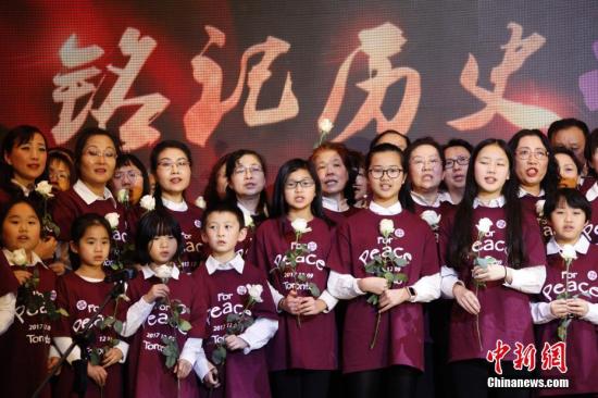 当地时间12月9日，加拿大安大略省各界华人共同举办的“南京大屠杀80周年追思会”在多伦多举行。来自华人社区及其他多个族裔社区的逾千名代表参加此次主题为“铭记历史，祈愿和平”的追思会。图为社区人士与孩子们在追思会上合唱《让世界充满爱》。 <a target='_blank' href='http://www.chinanews.com/'>中新社</a>记者 余瑞冬 摄