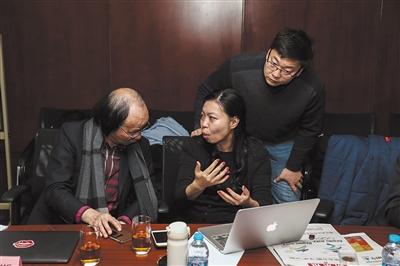 12月16日，2022年冬奥特许商品评审会现场，特许生产商与会徽设计者林存真(中)交流特许商品的改进思路。图片来源：新京报