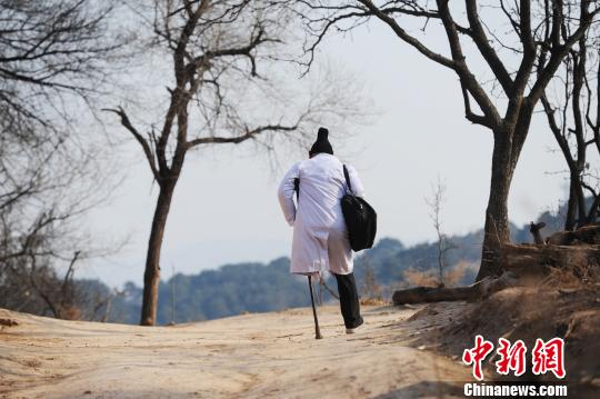 头发花白，身穿白大褂，拐杖断了一根又一根，三轮车骑坏4辆，背着药箱在山路上蹒跚前行……在岭村，每一位村民心中都印着这样一个背影。　徐霞 摄
