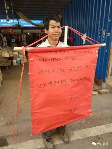 贫困户脱贫后举牌上街 领完免费猪苗还想领母牛