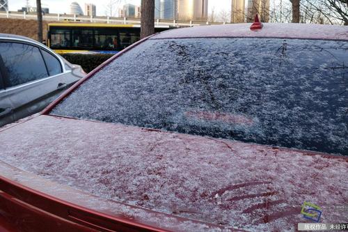 图为北京朝阳区五元桥附近车辆上覆盖的小雪。