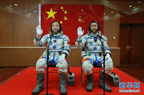 2016年10月17日，神舟十一号航天员出征仪式在酒泉卫星发射中心举行。这是航天员景海鹏（左）、陈冬在出征前挥手。新华社记者 李刚 摄 图片来源：新华网