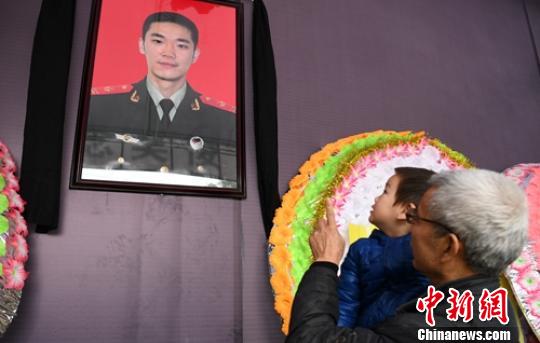 2岁多的儿子在吴俊寰遗像前。　刘忠俊 摄