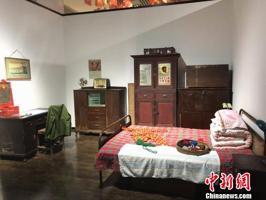 走进展厅，仿佛立刻“穿越”到新中国成立之初的新春家庭。老式票证、花布被单、革命海报……每一处细节，都尽可能地以“场景复原”的方式，还原五六十年代尽管物质贫乏但喜庆热闹的新年。　杨颜慈 摄