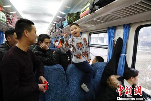 孩子坐在座椅上嘲笑着父亲分辨不出鸭与鹅。　殷立勤 摄