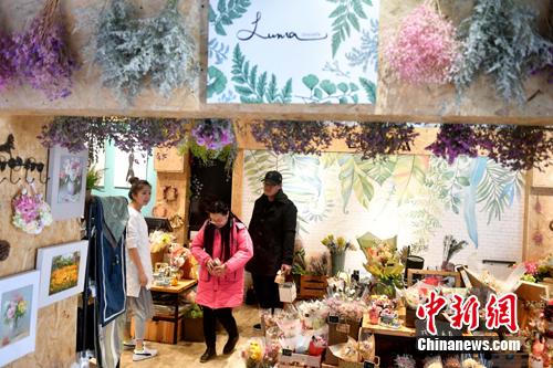 图为李函儒招呼店里的顾客。 吕明 摄