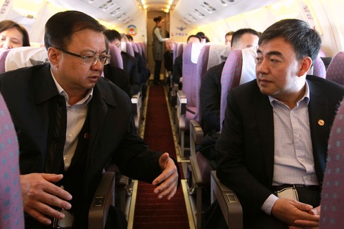 出席全国全国政协十三届一次会议的委员陆续抵京。图为住宁全国政协委员何晓勇和马宗保在飞机上就提案的细节进行沟通。 范文杰    摄影报道