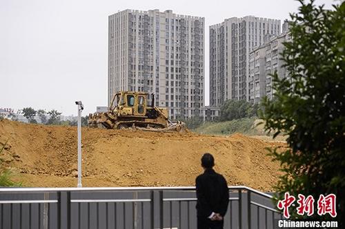 市民观望湖南长沙一楼盘工地上的推土机作业。 <a target='_blank' href='http://www.chinanews.com/'>中新社</a>记者 杨华峰 摄