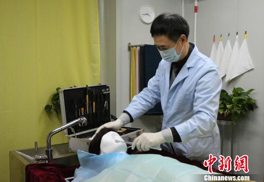 图为殡仪馆的遗体整容师用人体模型演示为逝者做面部清洁。　赵晓 摄