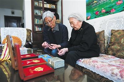周智夫二女儿周卫平和母亲娄淑珍静静地端详着周智夫生前所获勋章。