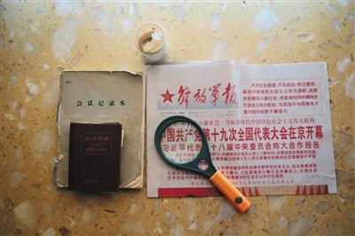 周智夫生前看的报纸、使用的放大镜、字典和笔记本。