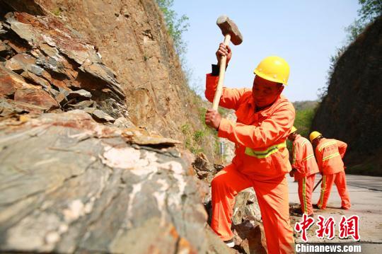 杨卫东带领工友们正在清理落石。　刘继东 摄