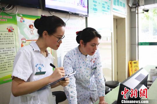 王梦琪(左)在和前辈学习引导病人就诊。　朱柳融 摄