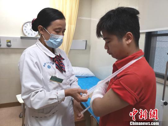陈小红在给病人包扎。　朱柳融 摄
