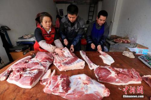 居民在家中切猪肉。谭凯兴 摄