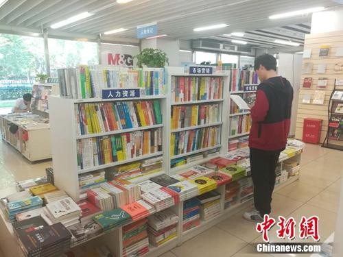 一位读者正在翻阅书架上的书籍。记者在走访中也了解到，不少读者表示，看到值得买的好书，不会过多考虑价格问题。上官云 摄