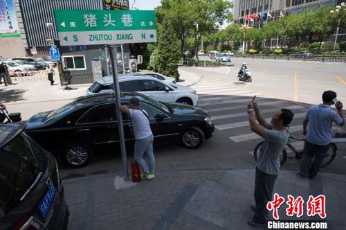 路人拍摄“猪头巷”路牌留念。　武俊杰 摄
