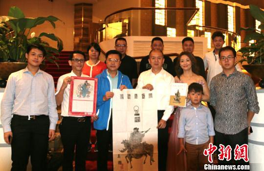 中国侨网向菲律宾侨领蔡祥维（右三）、林志农（左二）赠送洛阳关林关帝像拓片、关公文化专著和关公像年历　林才强　摄