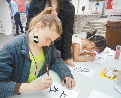 中国侨网6月10日，为期4天的第三届比利时列日省“中国城会”活动落下帷幕。图为列日大学的学生在活动现场学习书法。 本报记者 任 彦摄 