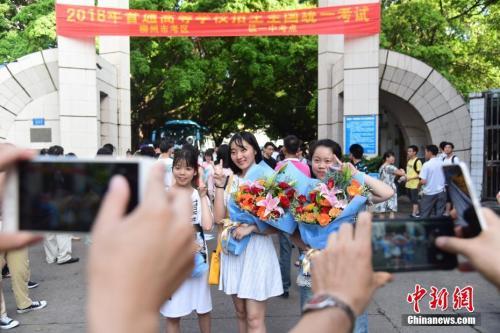 资料图：2018年高考结束，家长为刚刚走出考场的孩子拍照留念。 王以照 摄 