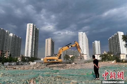 资料图：工人操作挖掘机在太原一商品房建设工地施工作业。<a target='_blank' href='http://www.chinanews.com/'>中新社</a>记者 韦亮 摄