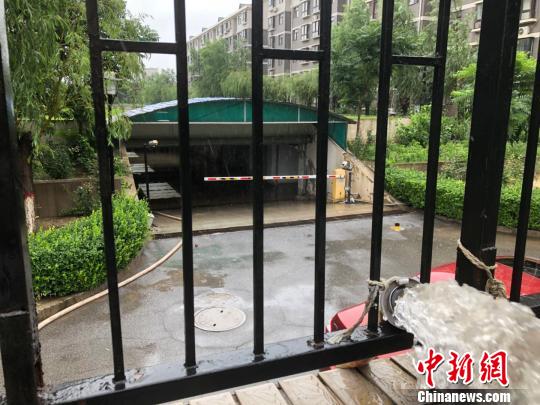 图为24日上午河北廊坊市某小区车库积水严重，物业加开临时管泵排水。　宋敏涛 摄