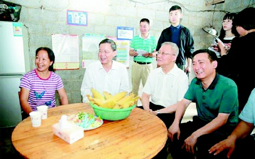 ▲调研组走进靖西市龙邦镇大莫村村民家中座谈交流，了解贫困户吕母千通过开办家庭酒坊，每月增收一千多元的脱贫经验。