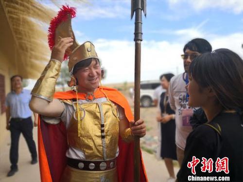 图为孙建军向游客介绍家乡以及自己和“古罗马”的故事。　魏建军 摄
