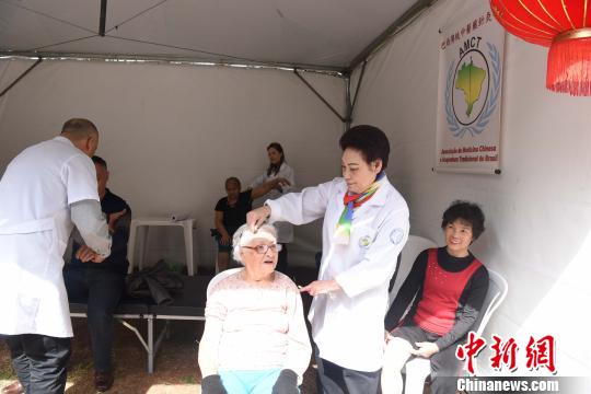 图为巴西传统中医药针灸学会会长惠青(右二)现场开展义诊。莫成雄 摄