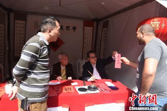 图为巴西中华书法学会会长刘树德(右二)现场展示中国书法。莫成雄 摄