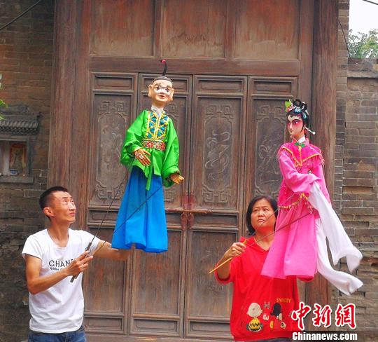 营员观看皮影戏和木偶戏。　杨杰英 摄