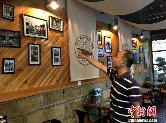 胡里山炮台管理处主任王勇介绍改造一新的瞭望台战地服务部内文化墙富装饰。杨伏山 摄