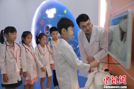 首批14名小体验者走进梦想医学院，穿上定制的白大褂，变身“见习小医生”。　芊烨 摄