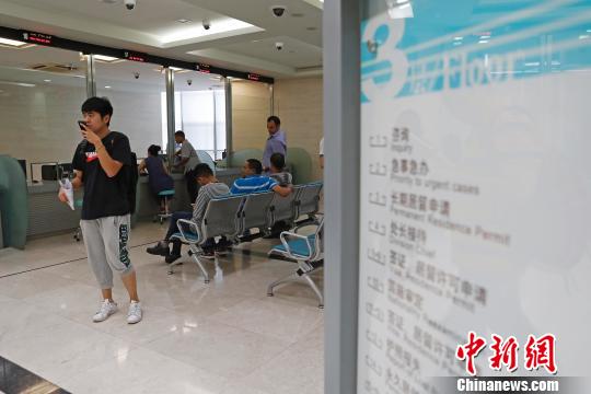 上海市公安局出入境管理局内，民众正在咨询和办理相关业务。　殷立勤 摄