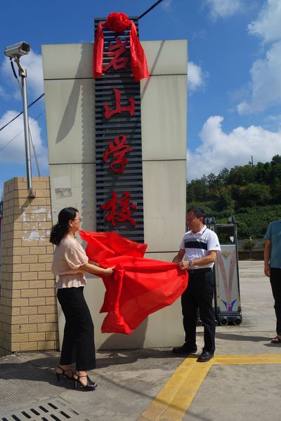 图1：新罗区政协副主席、民盟新罗区工委主委黄美玲（左）与岩山镇镇长李承清为复办的岩山中学揭牌。