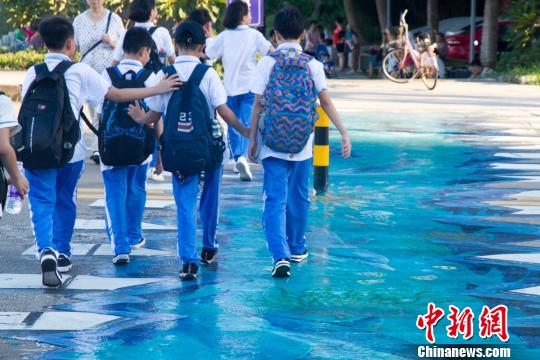 学生在海口首条3D斑马线上通过。　凌楠 摄