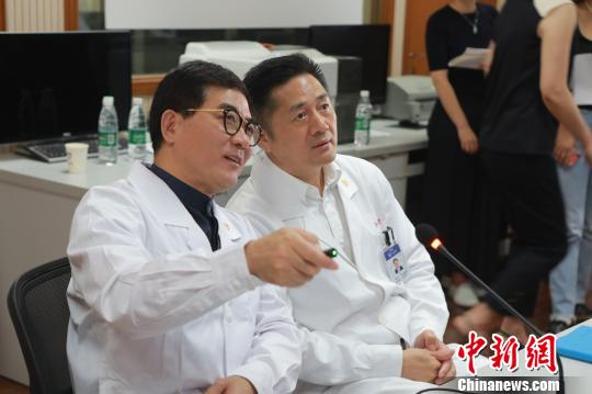 　院士们紧盯着屏幕，不时通过互联网远程视教系统，与主刀医师用简洁的专业术语进行沟通，不时提出指导意见。　芊烨 摄