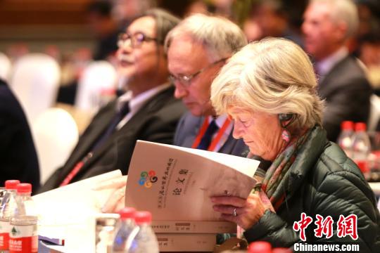 图为在开幕式现场，外国学者阅读《第五届尼山世界文明论坛论文集》。　梁犇 摄