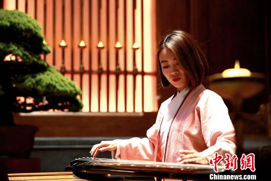 图为志愿者在开幕式会场展示琴艺。　梁犇 摄
