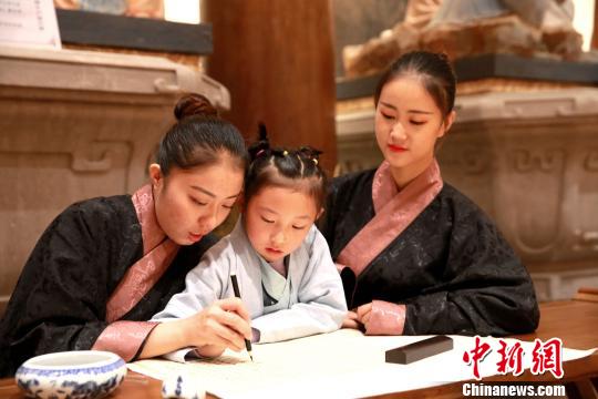 图为志愿者在开幕式会场展示中国书法。　梁犇 摄