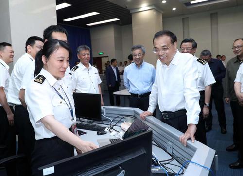图为今年5月21日李克强考察海关总署时听取推进通关一体化便利化进展情况汇报。