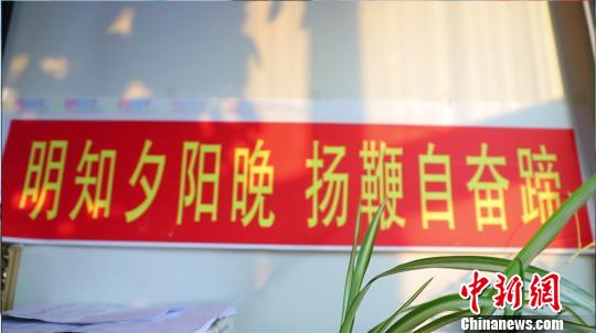 图为贾智杰家墙上挂的“自勉横幅”。　马来虎 摄
