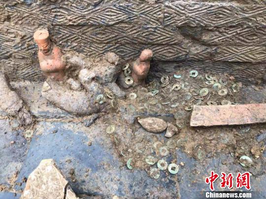 图为墓葬出土的陶俑和铜钱。(钟欣摄)