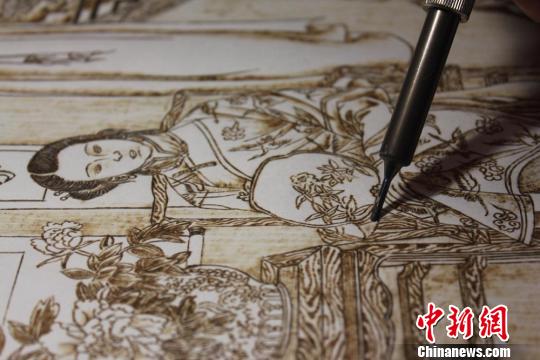 图为正在创作中的烙画作品。　徐雪 摄
